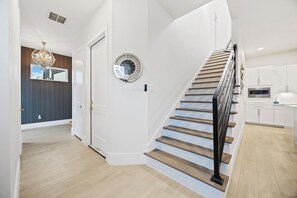 Ein modernes Interieur mit Treppe, einer Uhr und einer Küchenzeile.