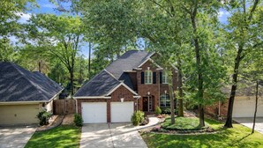 A residential house with a garage, a driveway, and a well-maintained lawn. - 4BR Near The Woodlands | Quiet Neighborhood | King Suite | Pet Friendly (Conroe)