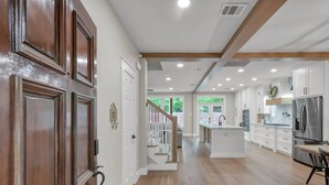 A spacious kitchen with white cabinets, a central island, and a stainless steel refrigerator. - 4BR Near The Woodlands | Quiet Neighborhood | King Suite | Pet Friendly (Conroe)