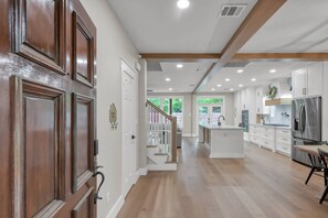 A spacious kitchen with white cabinets, a central island, and a stainless steel refrigerator. - 4BR Near The Woodlands | Quiet Neighborhood | King Suite | Pet Friendly (Conroe)