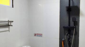 A small, clean bathroom with a toilet, a shower, and a hand dryer.