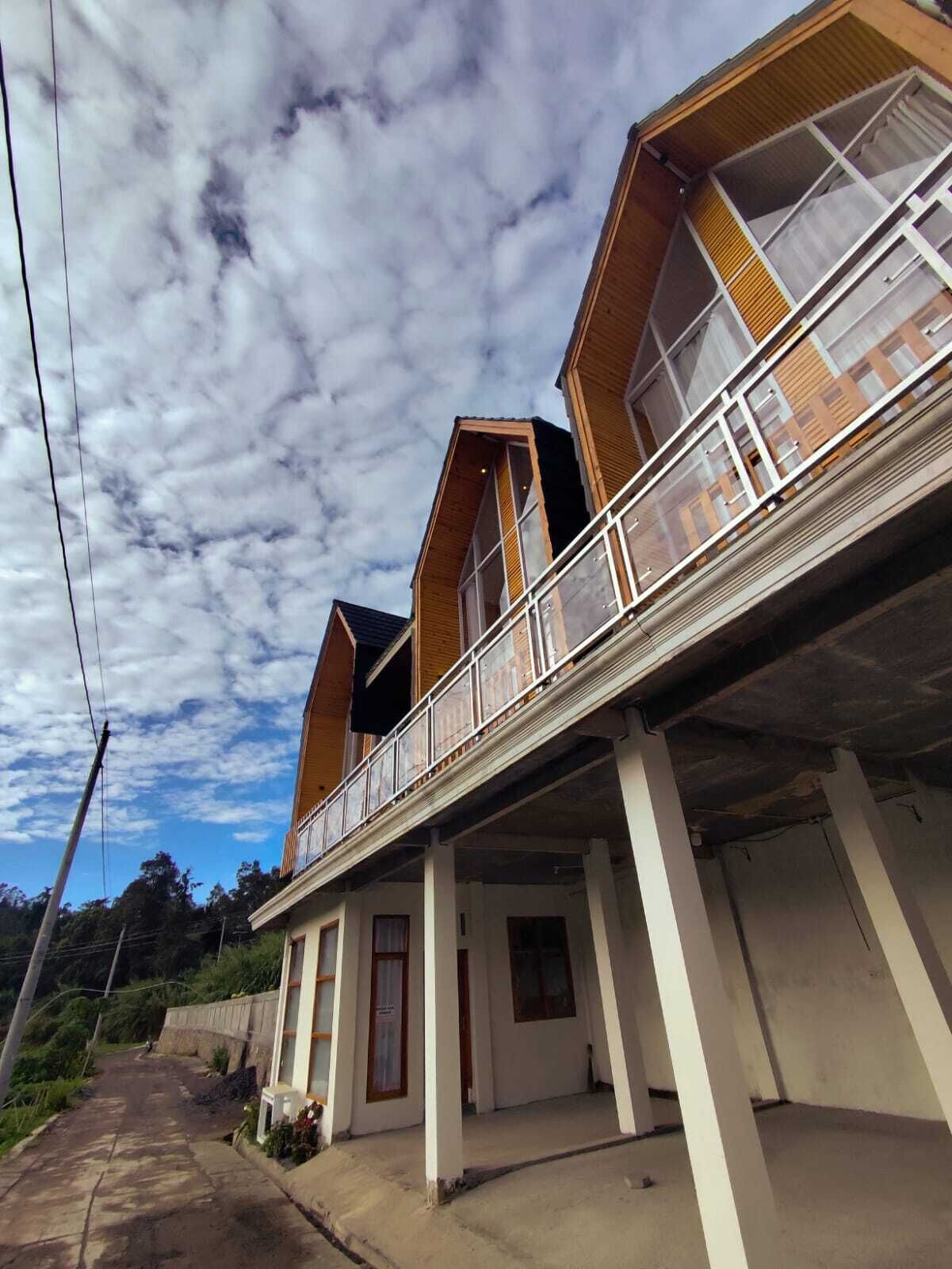 Un bâtiment à deux étages doté d’un balcon, d’une façade en bois et surplombant un ciel dégagé.
