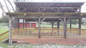 A wooden gazebo with a covered seating area and a fenced deck. - Private Lakeside Retreat on Turtle Creek (Kerrville)