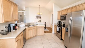 A modern kitchen with wooden cabinets, stainless steel appliances, and a central island.