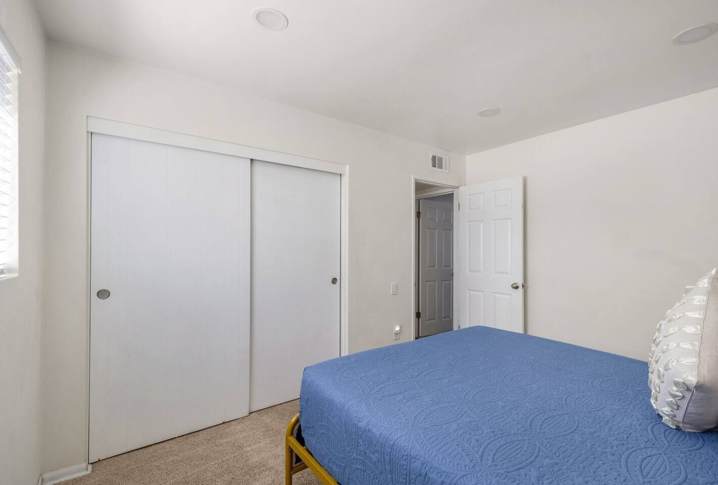 Un dormitorio con cama, armario y puerta que da a otra habitación.