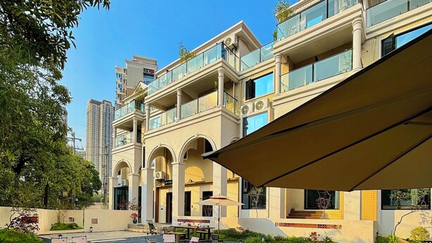 A courtyard with a pool, outdoor seating, and a building with balconies. - Quanzhou About Meisu (Quanzhou)