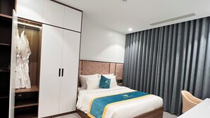 Une chambre d’hôtel moderne équipée d’un lit, d’une armoire, d’un bureau et d’une chaise.