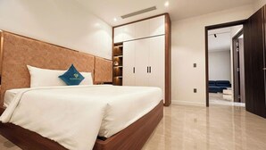Une chambre moderne avec un grand lit, une armoire intégrée et une vue sur une autre pièce.