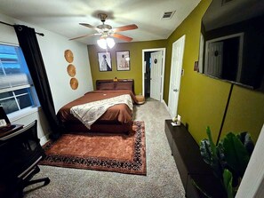 A bedroom with a bed, a ceiling fan, a window with blinds, and a door. - Spacious 3BR w/ Hot Tub, Grill & Game Room Near NRG, Med Ctr, Downtown & Hobby (Houston)