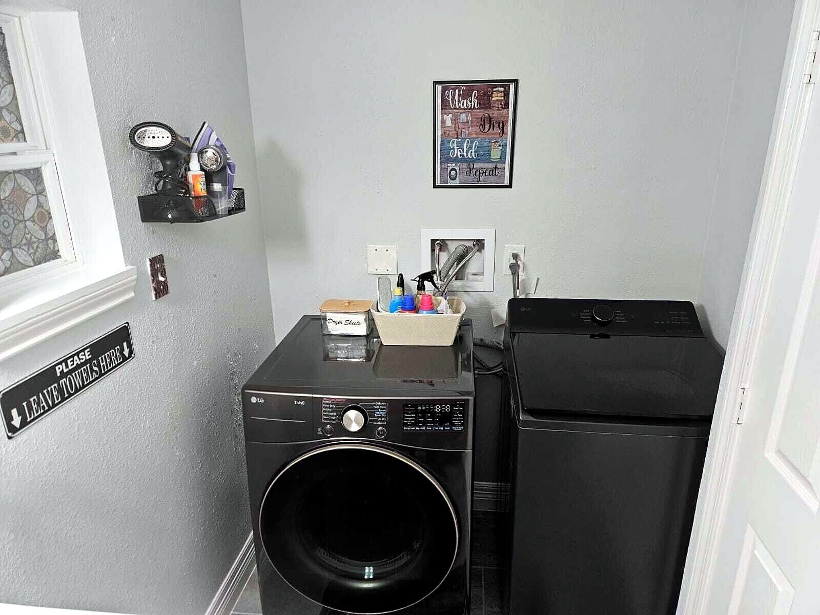 Un espace buanderie équipé d’un lave-linge, d’un sèche-linge et d’un panneau indiquant l’endroit où sont rangées les serviettes.