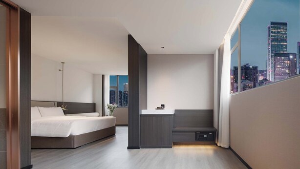 A modern hotel room with a bed, bedside table, and a city view. - Nicesoe S Hotel Chengdu Kuanzhai Alley (Chengdu)