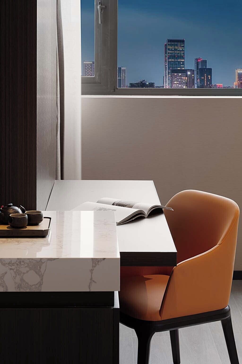 Una habitación moderna con vistas a la ciudad, una mesa blanca, una silla marrón y una bandeja con teteras y tazas.