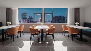 A modern hotel room with a city view, a dining area with a table and chairs, and a large window. - Nicesoe S Hotel Chengdu Kuanzhai Alley (Chengdu)