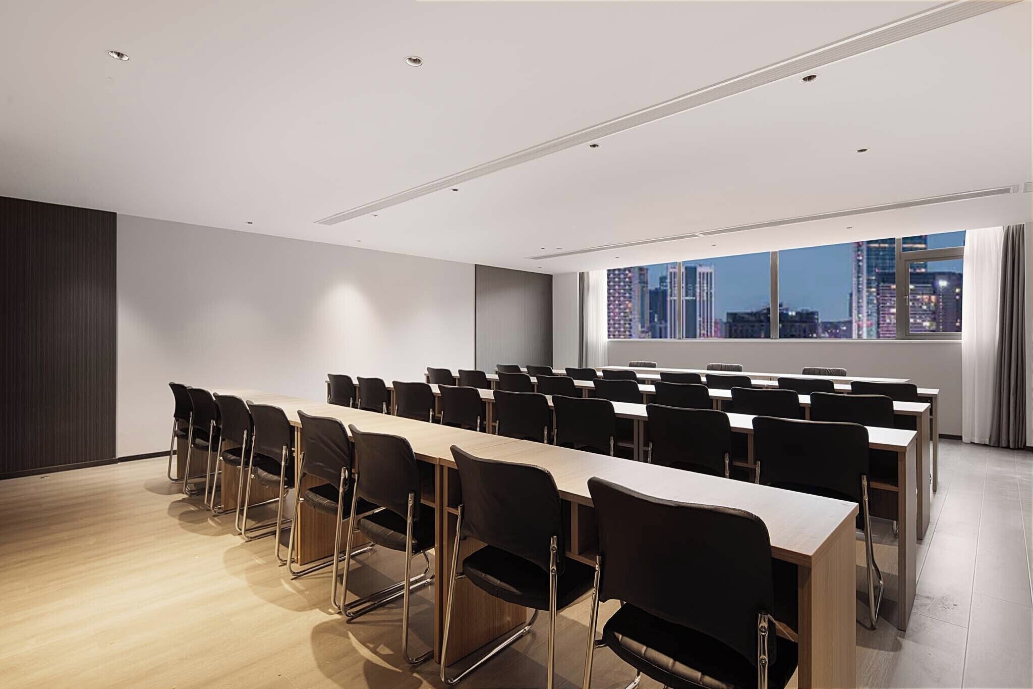 A conference room with a long table and chairs, large windows with a city view, and a modern interior design.