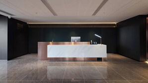 A modern reception desk with a marble top, recessed lighting, and a dark wall backdrop. - Nicesoe S Hotel Chengdu Kuanzhai Alley (Chengdu)