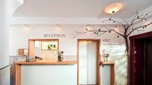 A reception desk with a sign indicating 'RECEPTION' and 'WC zu den Zimmern 101-106 207-214'. - Gasthof zum weißen Lamm (Sommerach)
