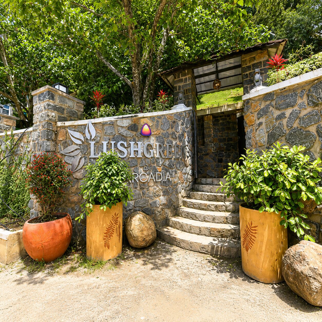 A stone wall with a sign reading 'LISHGREEN ARCADIA' and a small entrance to a building.