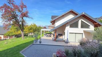 A modern house with a covered patio, a well-maintained lawn, and a clear blue sky.
