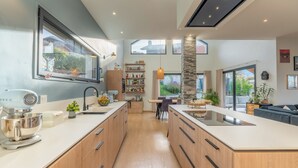 Uma cozinha moderna com armários de madeira, uma ilha central e um espaço de refeições com mesa e cadeiras.