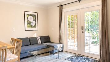 Un salon moderne avec un canapé, une table basse et un coin repas.