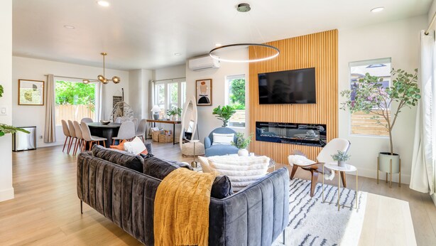 A modern living room with a sofa, television, and dining area. - AC / New Remodel / Chef's Kitchen / BBQ / Cap Hill (Seattle)