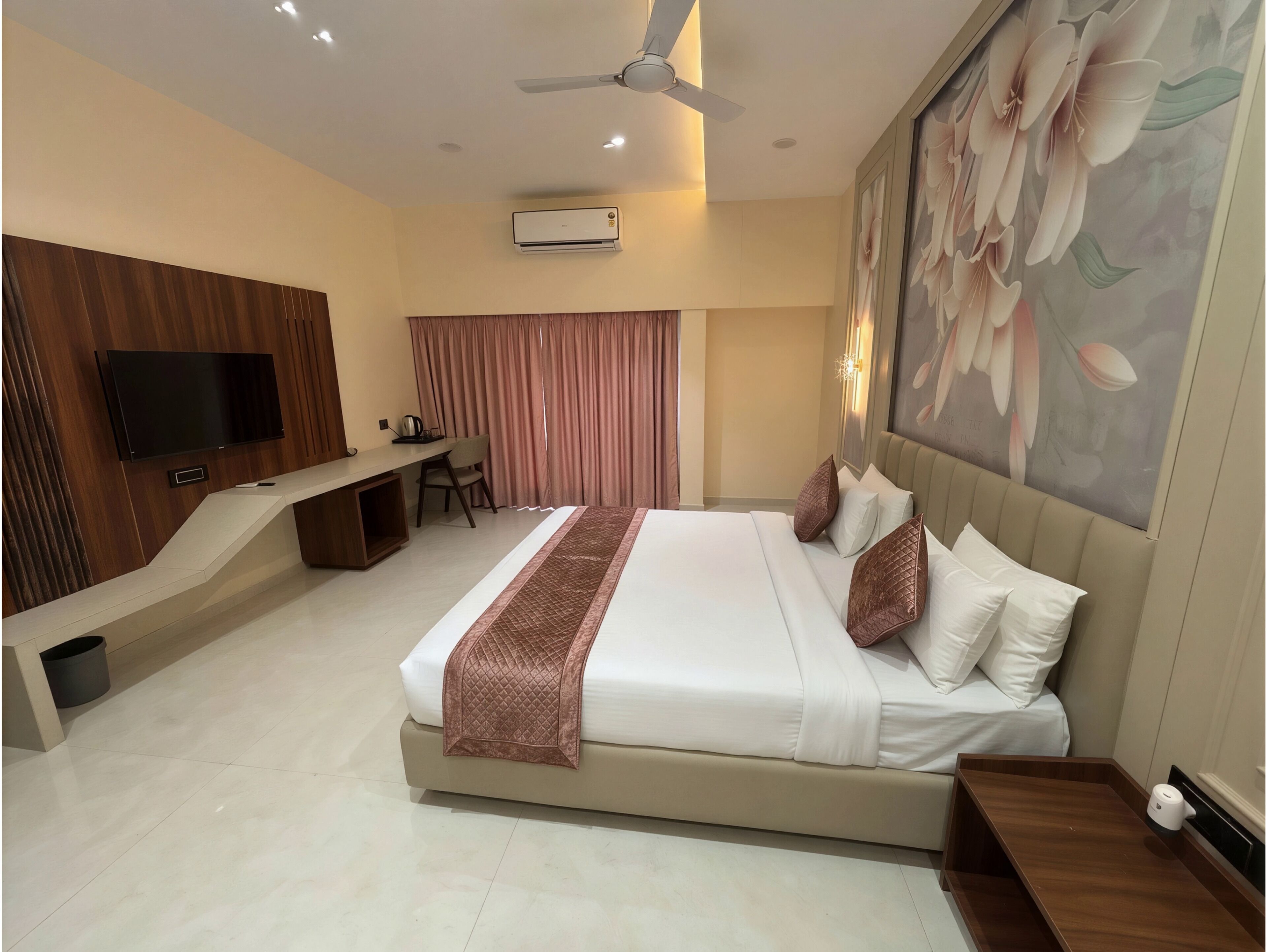 Une chambre d’hôtel équipée d’un lit, d’un bureau, d’une télévision et d’un appareil de climatisation.