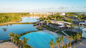 A resort with a large central pool, palm trees, and a view of the surrounding landscape. - Villa with jacuzzi and terrace · Ideal Easter (Punta Cana)