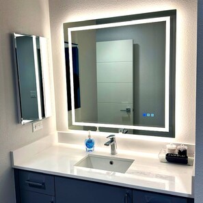 A bathroom with a large mirror, a sink, and a bottle of hand soap. - Resort 1BR Oasis  Pool  Spa  Gym Reno Getaway (Reno)