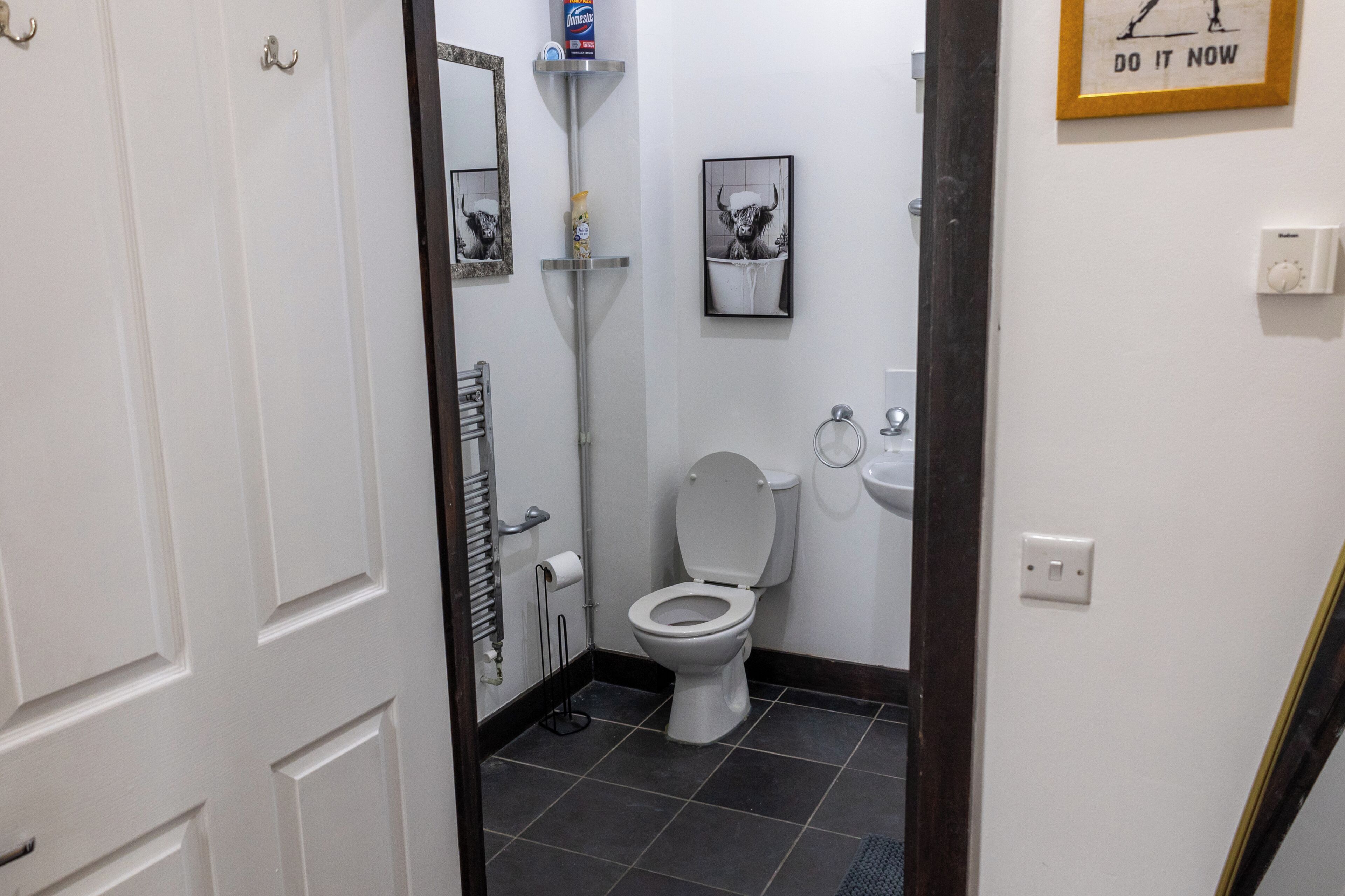 Un bagno con il water, un lavandino, uno specchio e un quadro incorniciato appeso al muro.