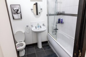 Een haardroger, handdoeken, zeep, toiletpapier
