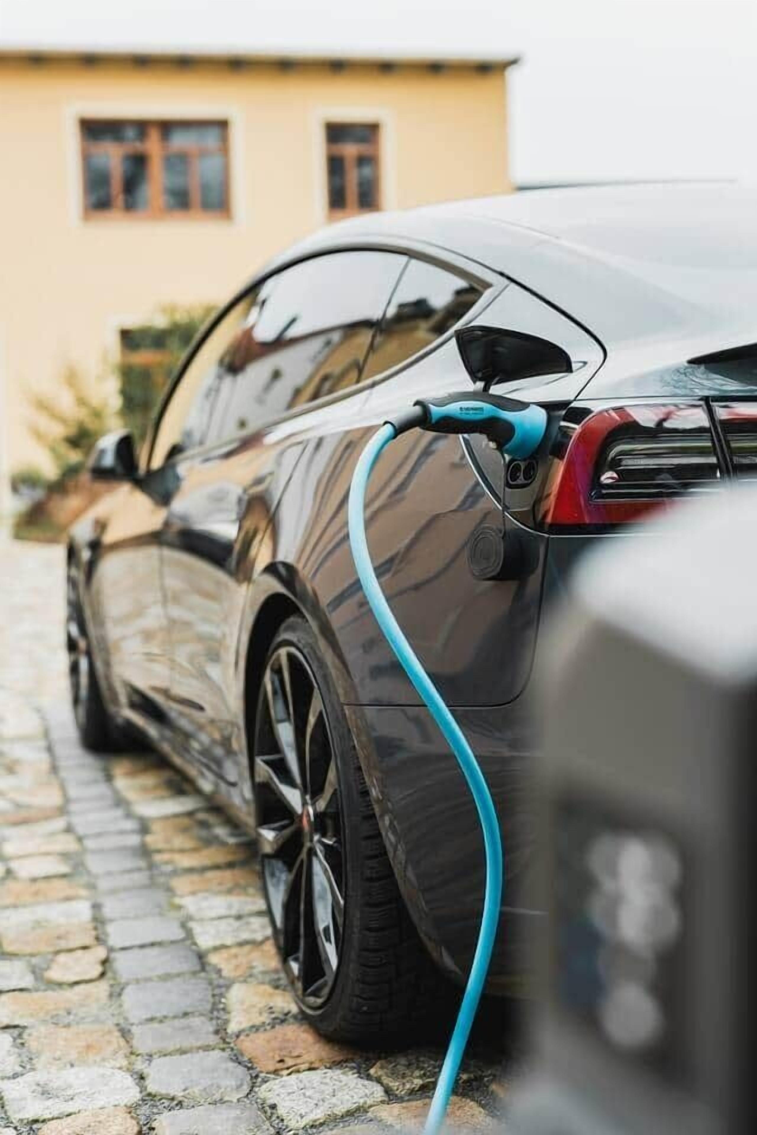 A parked electric car with a charging cable connected to it.
