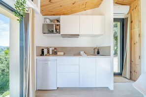 A modern kitchen with white cabinetry, a built-in microwave, and a dishwasher. - Tiny house-private jacuzzi-panoramic view-saint-paul-de-vence (Saint-Paul-de-Vence)