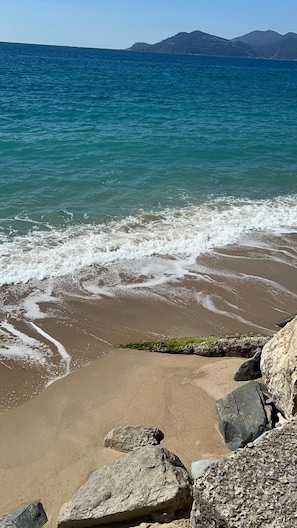 A beach with waves, rocks, and distant mountains. - Studio with sea view -4 people- Terrace - Swimming pool (Cannes)