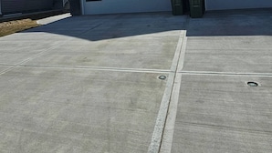 Une maison à deux étages avec un garage, une allée et un ciel dégagé.