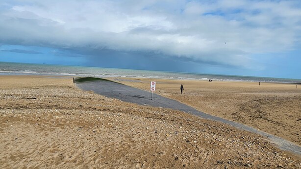 A beach with a paved walkway, a no swimming sign, and a distant ship on the horizon. - Studio Méva (Courseulles-sur-Mer)