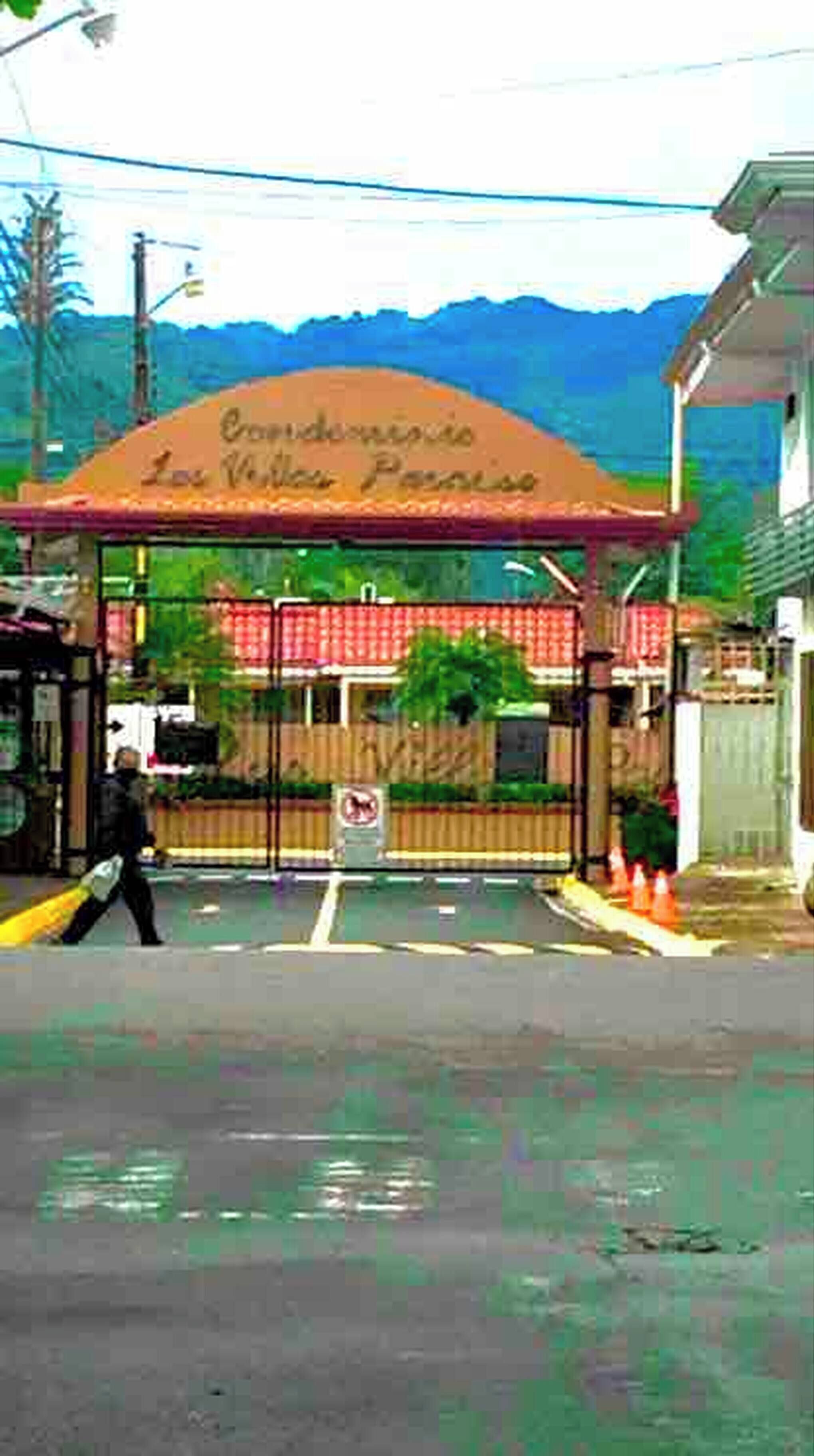 Uma entrada fechada por portão com uma placa que diz 'Condominio Las Vidas Perdidas'.