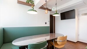 Un comedor moderno con una mesa redonda, dos sillas e iluminación colgante.