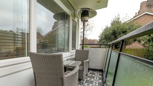A balcony with wicker furniture, a table, and a lamp. - Lovely 2BR flat w balcony, Golders Green tube 5min (London)