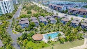 A resort with multiple bungalow-style buildings, a central swimming pool, and lush greenery. - Nova Villas Phu Quoc (Phu Quoc)