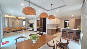 A modern living space with a dining area, kitchen, and seating area. - Nova Villas Phu Quoc (Phu Quoc)
