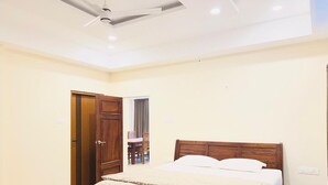Un dormitorio con cama, una puerta de madera y un ventilador de techo.
