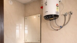 A bathroom with a white sink, mirror, toilet, and a wall-mounted water heater. - WHITE & BLUE (New Delhi)