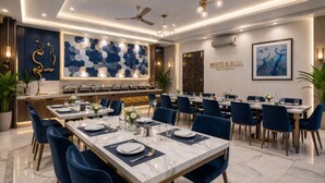 A restaurant with marble-topped tables, blue chairs, and a modern interior design. - WHITE & BLUE (New Delhi)