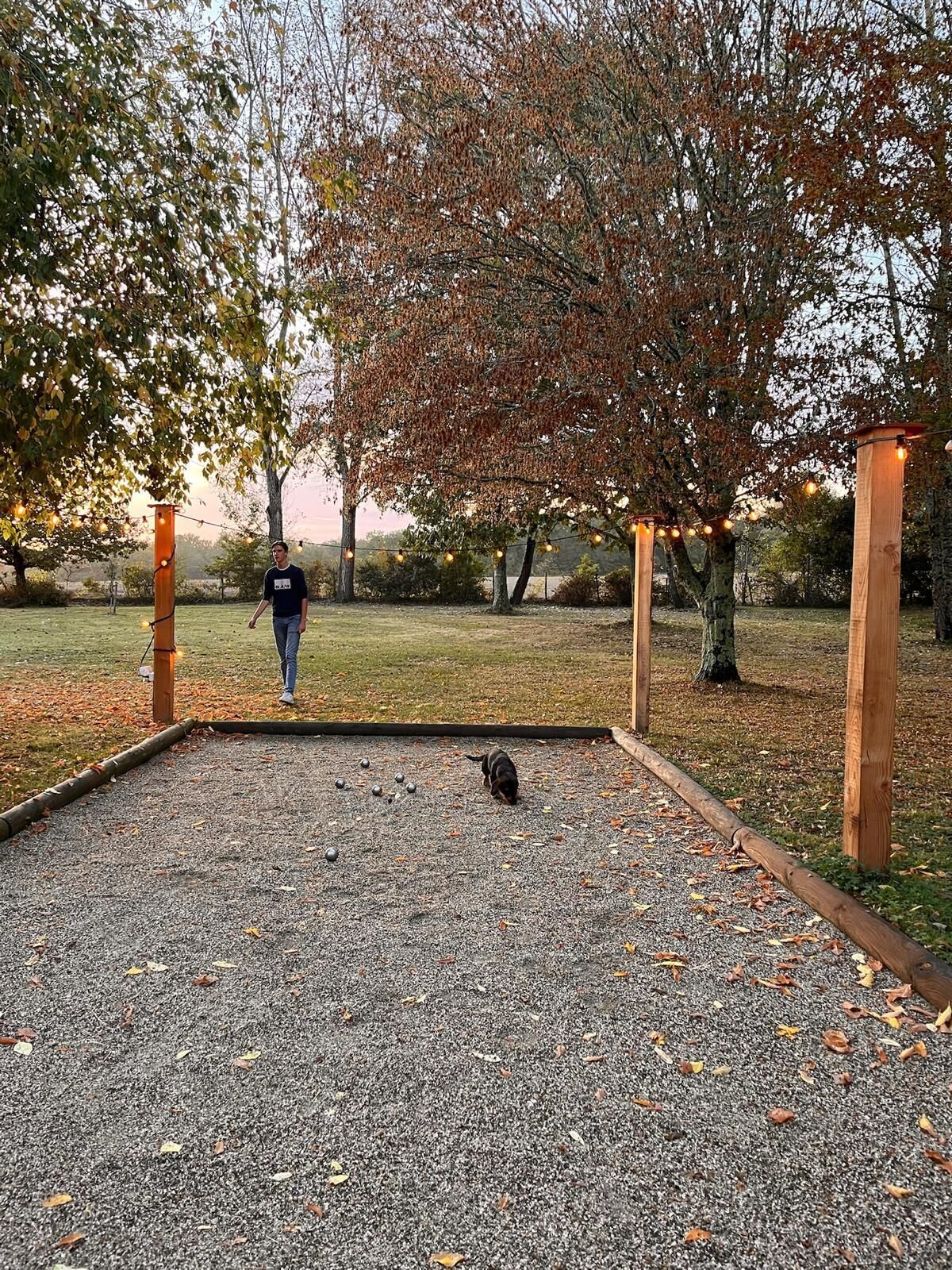 Ein Park mit Kiesweg, Bäumen und einer entfernten Person.