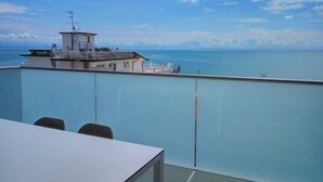 A balcony with a clear view of the sea and a distant building. - Beautiful duplex penthouse in Lignano (Lignano Sabbiadoro)