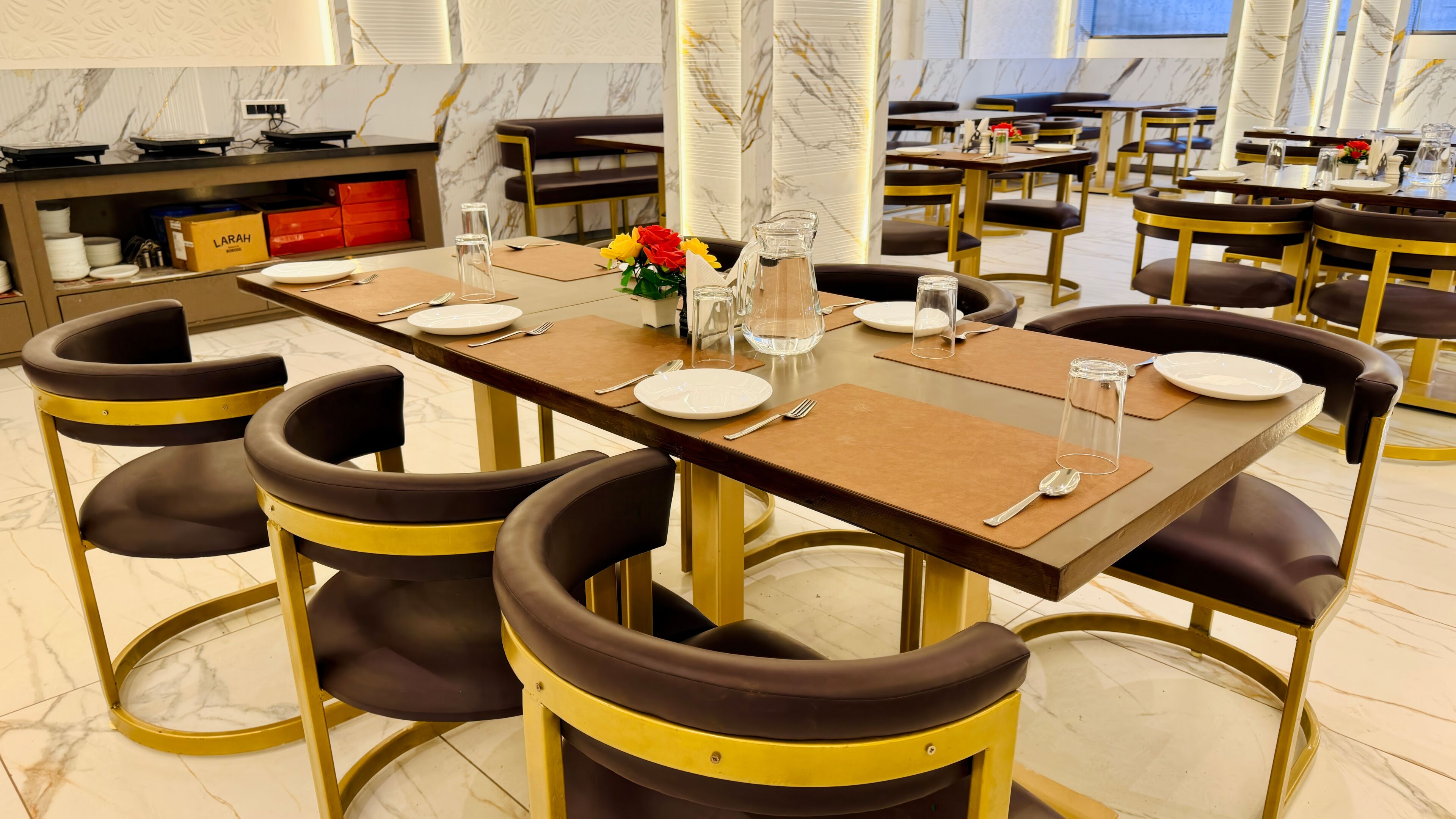 A dining area with marble flooring, modern furniture, and a clean, organized layout.