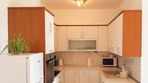 A compact kitchen with a microwave, kettle, and a small refrigerator. - Cozy 2-bedroom apartment Near the Sea in Ika - with Terrace, AC & Free Parking (Ika)