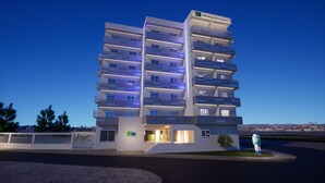 Et flereetagers Holiday Inn Express hotel med altaner, tydelig indgang og frit udsyn til byens skyline.