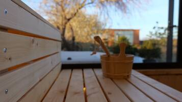 A wooden bench with a wooden bucket and a spoon.