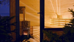 Un intérieur en bois avec une cheminée, une fenêtre et une vue sur l’extérieur.
